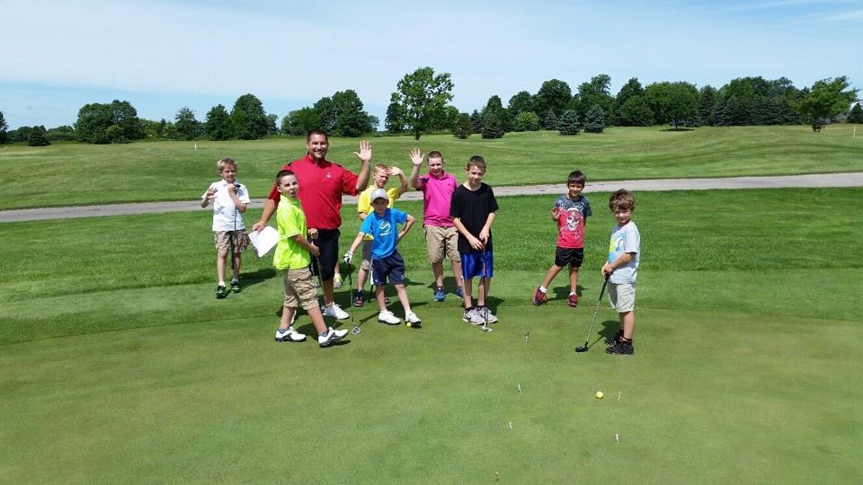 junior golfer and instructor on the green